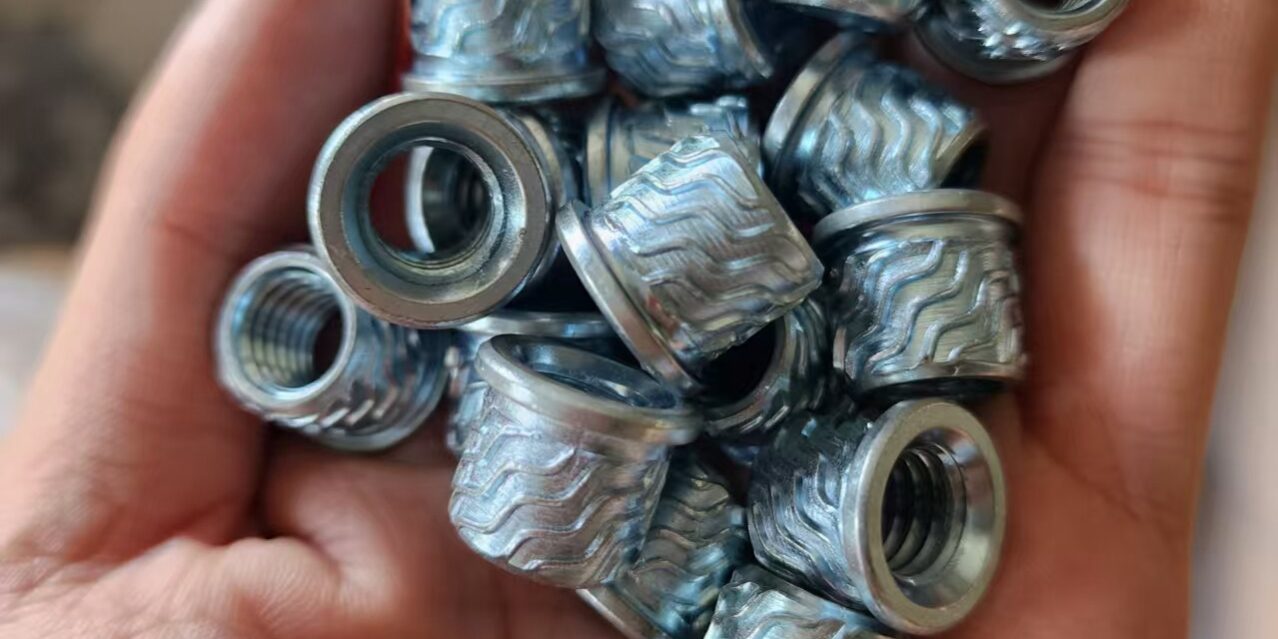 Industrial blind fasteners: Close-up of knurled rivet nuts for robust sheet metal assembly
