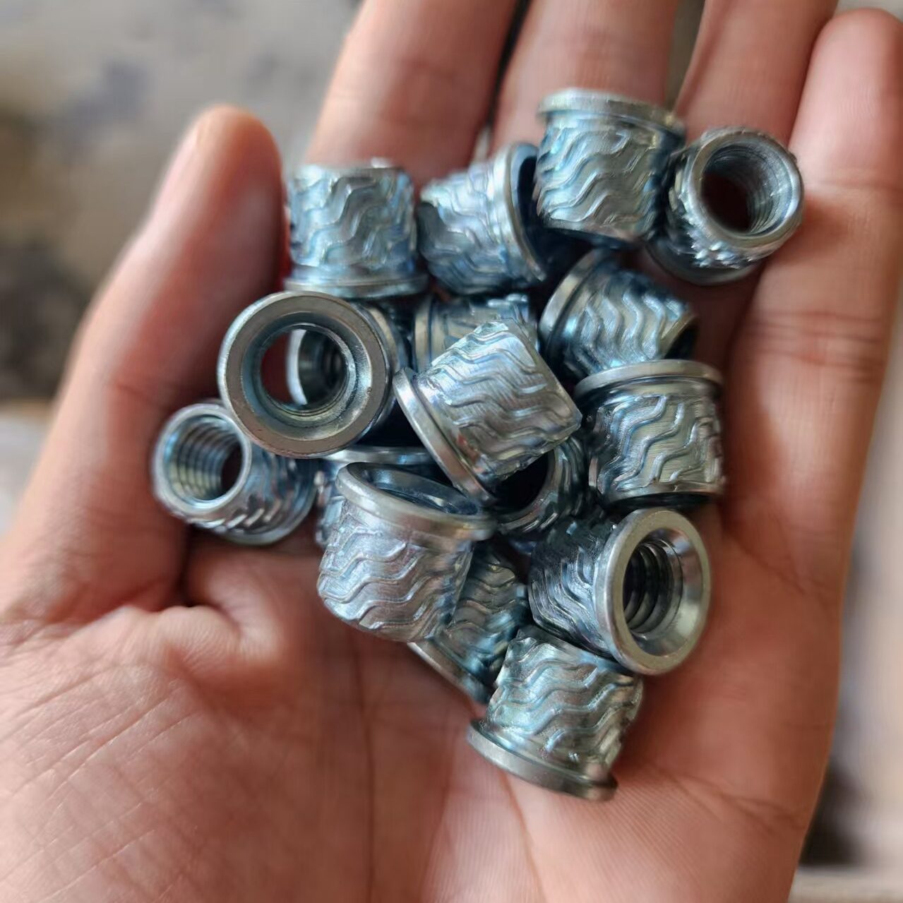 Industrial blind fasteners: Close-up of knurled rivet nuts for robust sheet metal assembly