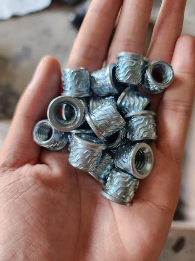 Industrial blind fasteners: Close-up of knurled rivet nuts for robust sheet metal assembly